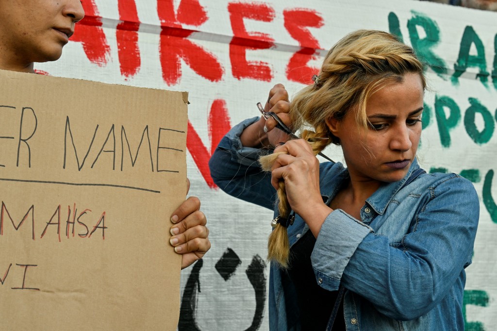 لاجئة إيرانية في أثينا تقص شعرها في تظاهرة تضامنية مع نساء إيران